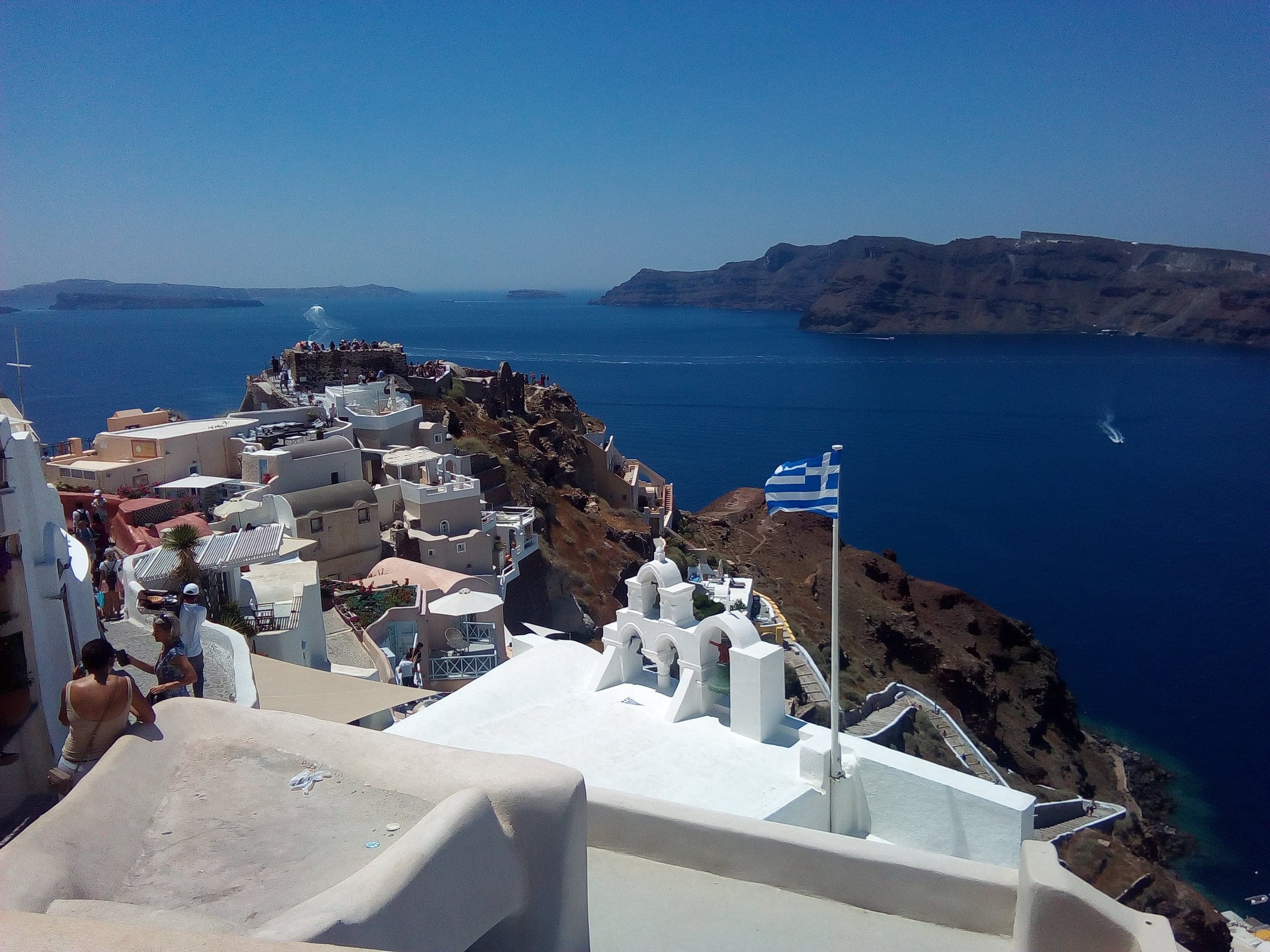 Whitewashed Santorini terraces descending toward the deep-blue caldera